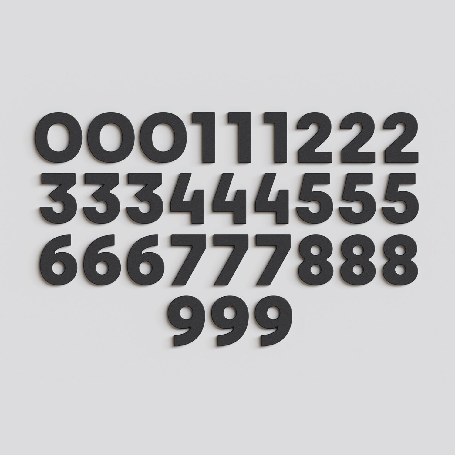 Full set of 30 black Wordbits number magnet letters and symbols laid out neatly on a grey background
