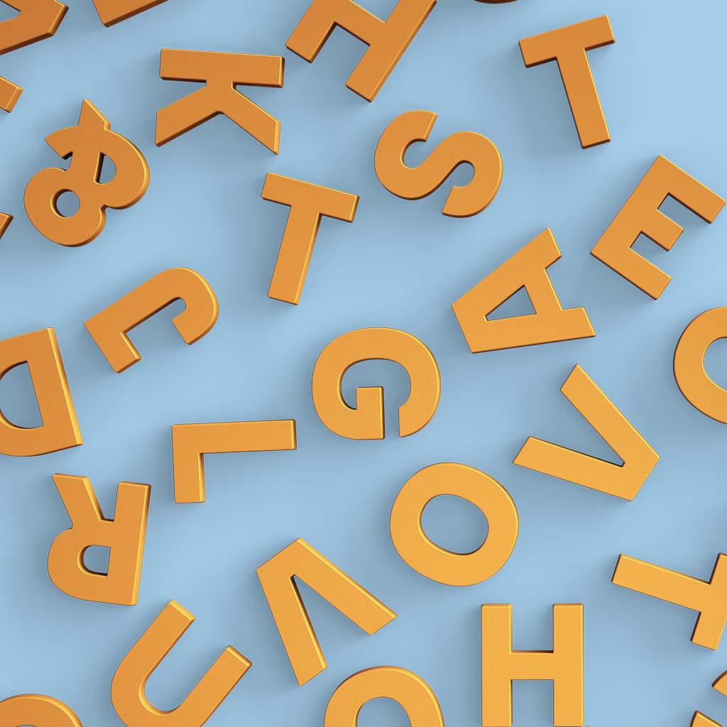 Mustard yellow Wordbits strong alphabet magnets placed randomly on a sky blue background
