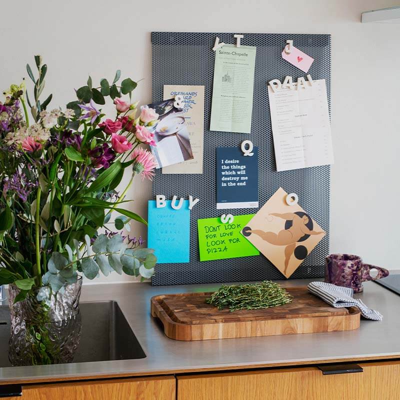 Grey Anne Linde magnetic noticeboard with white Wordbits magnet letters holding up shopping lists and notes in the kitchen home of Thus The Fuss